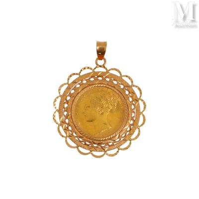 un gros plan d'une pièce d'or sertie dans un pendentif, sur fond blanc
