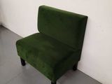 a green chair against a white wall in an empty room