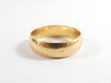 gros plan d'une bague en or sur une surface blanche
