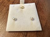 a close up of a pair of earrings on a wooden table