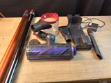 plusieurs modèles différents d'aspirateurs et d'accessoires posés sur une table en bois