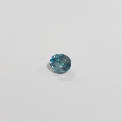 a close up of a blue diamond on a white surface