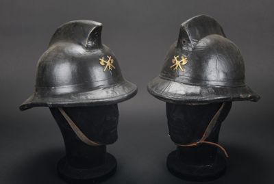 deux casques noirs ornés d'étoiles dorées, posés sur une surface noire