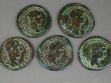 quatre pièces de monnaie romaines anciennes, avec une tête romaine d'un côté et une autre tête romaine de l'autre