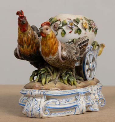 une figurine représentant un coq et une poule sur une charrette
