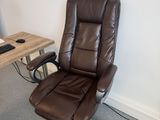 a brown office chair sitting in front of a computer desk