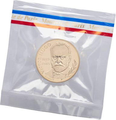 the coin is in a clear plastic bag with a red, white, and blue stripe
