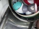 a bowl full of dishes sitting on top of a sink