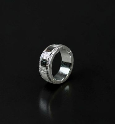 a close up of a silver ring with diamonds on a black surface