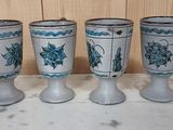 four blue and white vases sitting on top of a marble counter top
