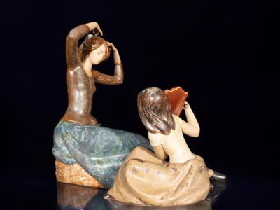 une figurine représentant un homme et une femme assis sur un rocher