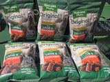 quatre sacs de croquettes pour chien posés sur une étagère dans un magasin