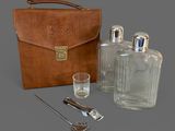 a leather case with a bottle, spoon, and a glass