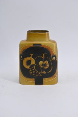un vase jaune orné d'un motif noir et doré