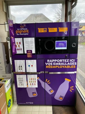 a purple vending machine in a store with a sign on it