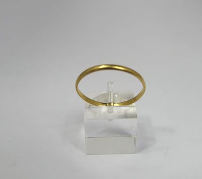 a close up of a gold ring on a clear stand