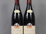 two bottles of wine sitting on top of a table next to each other
