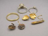 cinq bagues différentes et une bague en or posées sur une table
