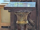 a table with a marble top in front of a wooden door