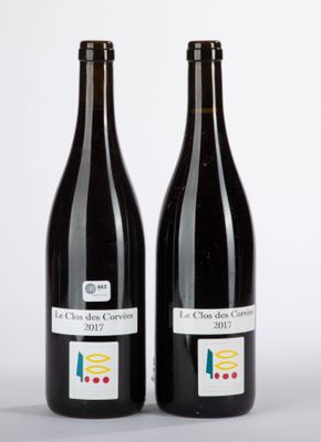 two bottles of wine sitting next to each other on a white surface