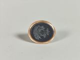 a close up of a gold ring with a coin on it