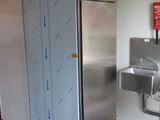 un évier en inox et un réfrigérateur en inox dans des toilettes publiques