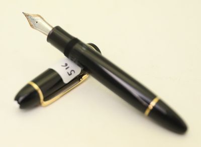 un stylo noir et un stylo doré sur une surface blanche
