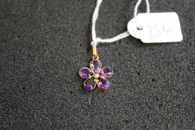 un gros plan d'un collier orné d'une fleur violette