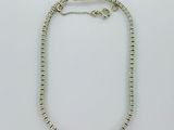 un bracelet en perles argentées muni d'un fermoir, sur fond blanc