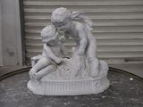 a statue of a boy and a girl sitting on a table