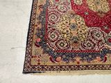 a red and gold rug on the floor in a room