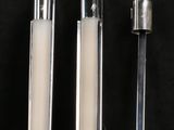 trois bougies sont alignées sur une surface noire, sur fond noir