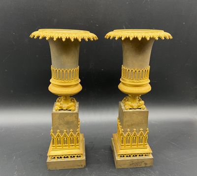 une paire de vases anciens en laiton sur socles, sur fond noir