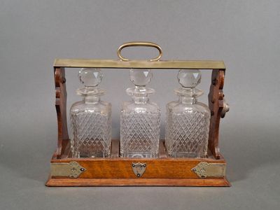 an image of a wooden and glass decanter with three bottles