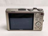 a silver digital camera sitting on a white surface