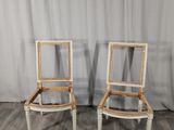 une paire de chaises peintes en blanc, posées contre un rideau, devant un rideau blanc