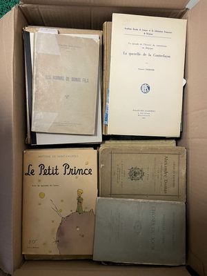 une boîte remplie de livres posés sur le sol