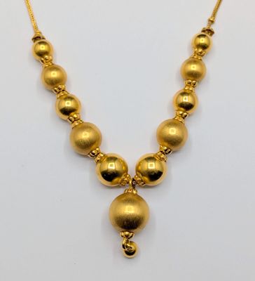 an image of a gold necklace on a white background