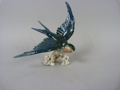 figurine of a blue bird with a skull on it ' s back