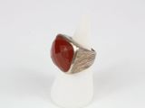 a close up of a ring with a red stone in it