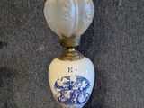 a lamp that has a blue and white vase on top of it