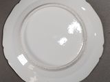 a white plate on a table with a black background