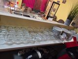 many glasses and plates on a shelf in a room