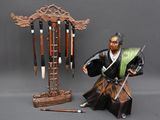 a figurine of a man holding a sword next to a pole