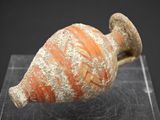 un petit objet en poterie posé sur une surface claire
