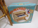 a box with a toy piano on it sitting next to a chair