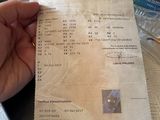 une personne tenant un ticket de caisse sur une table