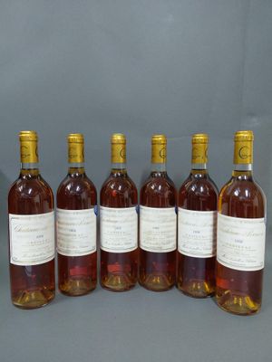 six bouteilles de vin sont alignées sur une table