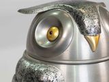 an owl statue sitting on top of a metal container