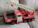 a toy fire truck that is sitting on a couch